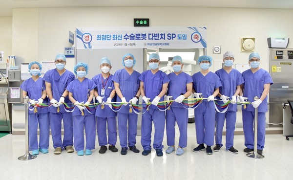 정용연 병원장(왼쪽에서 여섯 번째) 등 화순전남대병원 임원진과 의료진들이 지난 1월 4일 수술실에서 열린 수술 로봇 다빈치 SP 도입 행사에서 테이프 커팅을 하고 있다.