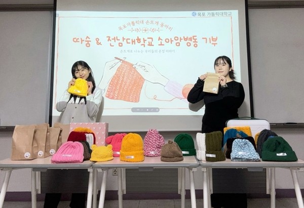 목포가톨릭대학교 손뜨개 동아리 ‘따숨’ 회원들이 직접 만든 털모자를 들고 있다.