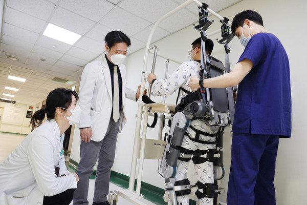 가톨릭대학교 여의도성모병원 재활의학과 장소연 교수(왼쪽)와 원선재 교수(왼쪽에서 두 번째)가 보행보조 재활 로봇으로 치료받는 환자의 상태를 살펴보고 있다.