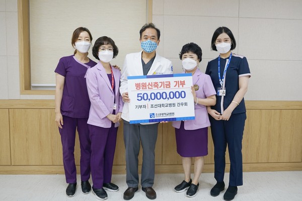 조선대병원 간우회 회원들이 새병원 신축을 위해 발전기금을 전달하고 단체로 기념 촬영을 하고 있다.