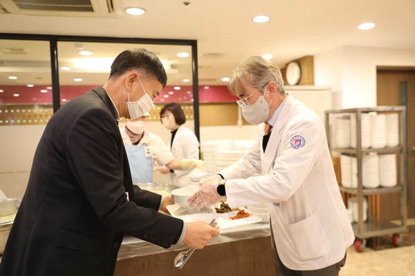 서일영 원광대병원장이 점식 배식을 하며 직원들에게 덕담을 건네고 있다.