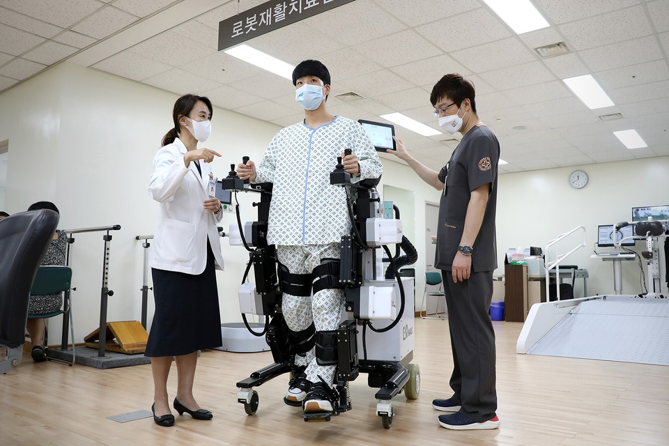 유지현 일산백병원 재활의학과 교수(사진 왼쪽)가 보행 로봇 치료 방법을 설명하고 있다.