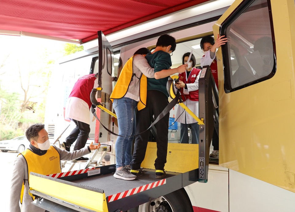 발달장애인이 치과 진료를 받기위해 리프트를 이용해 고려대의료원 이동형 진료버스에 올라타고 있다