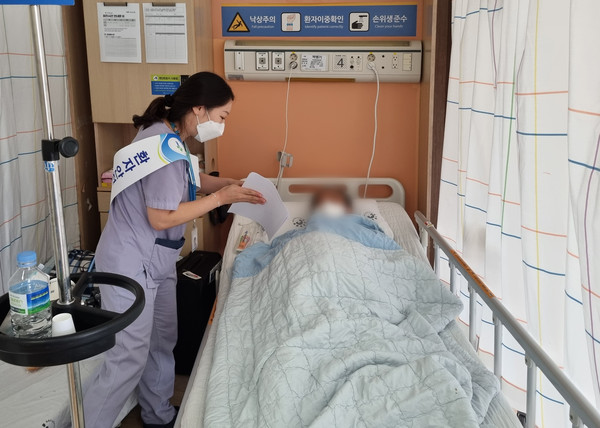 병실을 찾아가 환자에게 환자안전에 대해 설명하고 있는 양산부산대병원 적정관리팀 간호사
