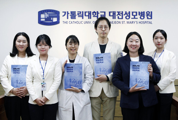 대전성모병원 감염관리실 직원들이 코로나19 감염관리대응백서를 들고 있다.
