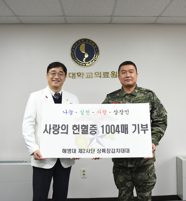 옥윤호 해병대 제2사단 대대장(사진 오른쪽)이 박준성 아주대병원장(왼쪽)에게 헌혈증을 전달하고 있다.
