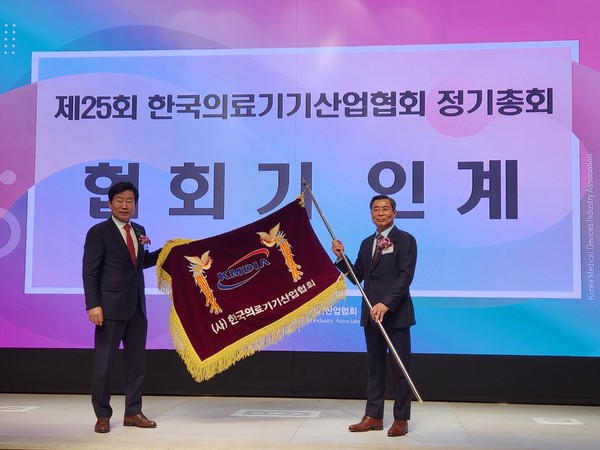 유철욱 전임회장(사진 왼쪽)이 김영민 신임회장에게 한국의료기기산업협회기를 전달하고 있다.